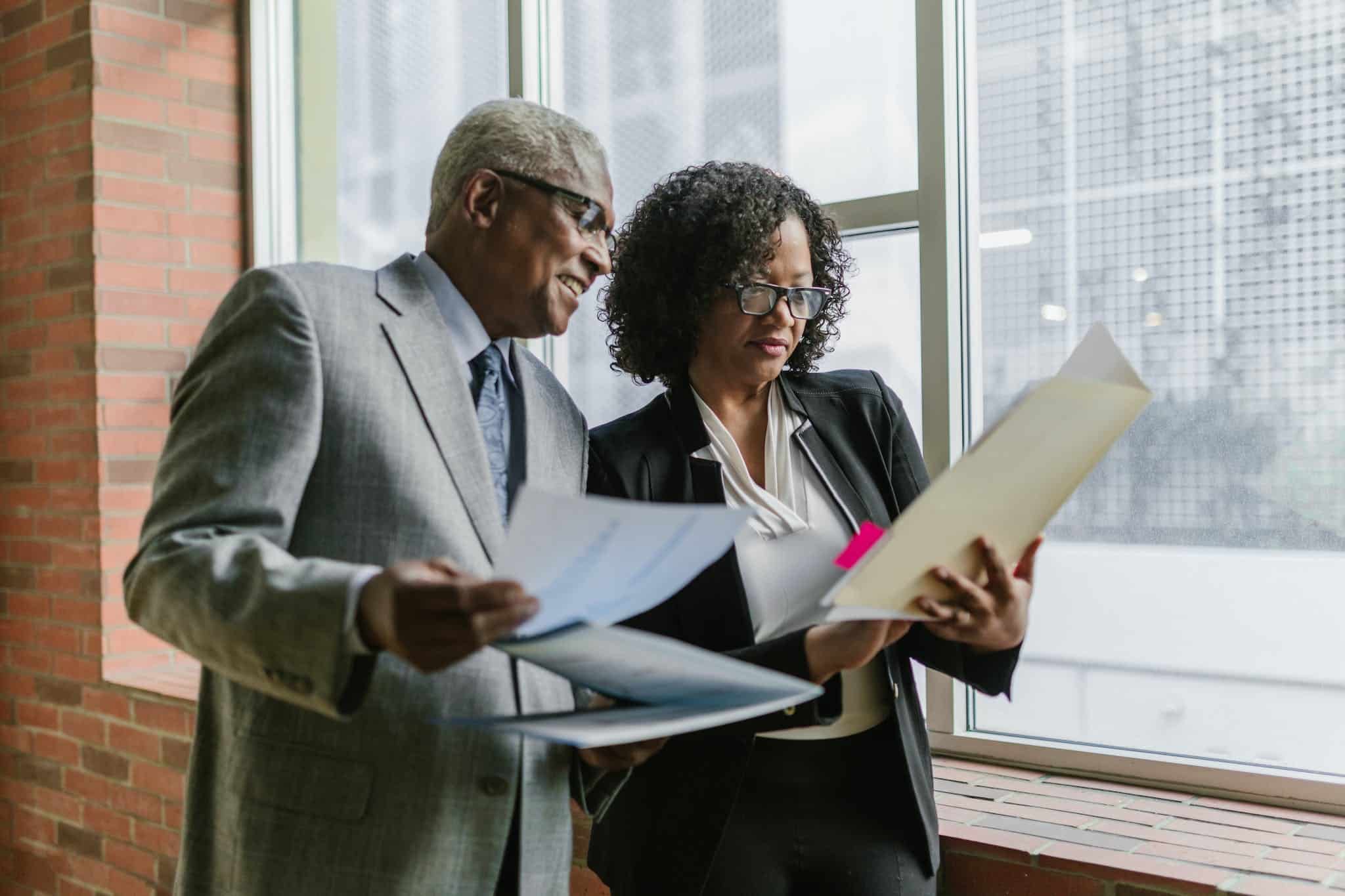 A Man and Woman Having Conversation while Standing Near the Window Matt/Dull Finish Presentation Folders