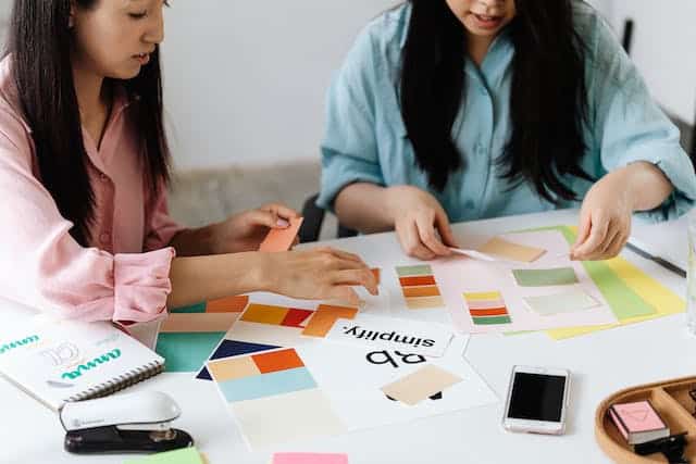 two women sorting Aqueous Coated Business Cards