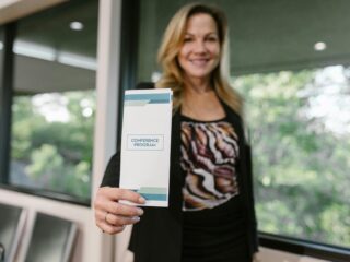 woman holding a Cadti printed business flyer for conference -Catdi Houston printing solutions